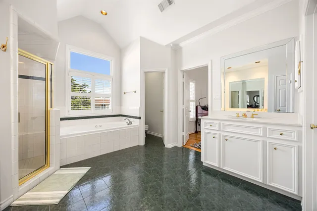 a spacious bathroom with a granite countertop tub sink and mirror