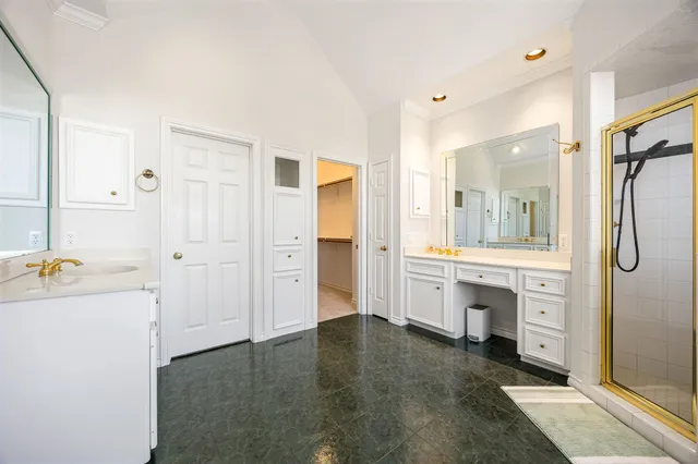 a spacious bathroom with a shower a sink and a mirror