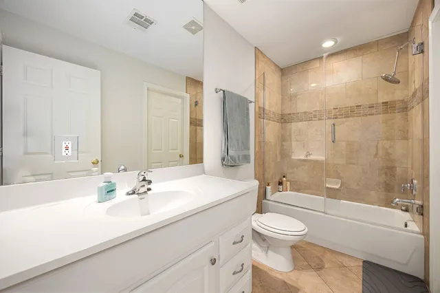 a bathroom with a sink a toilet and a large mirror