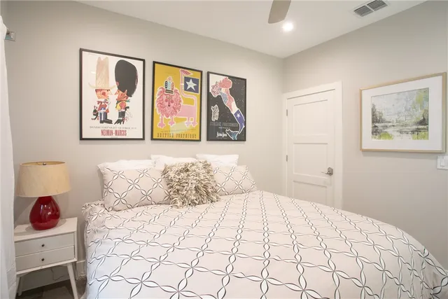 a bedroom with a large bed and a painting on the wall