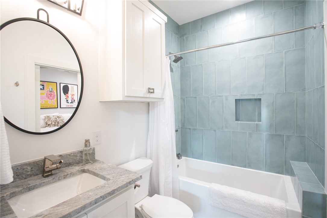 6613 Woodrow Avenue Austin, TX 78757 - Photo 16 of 27 a bathroom with a granite countertop sink mirror vanity and a bathtub