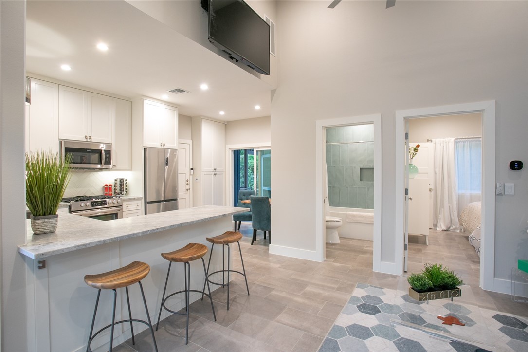 6613 Woodrow Avenue Austin, TX 78757 - Photo 5 of 27 a large kitchen with stainless steel appliances kitchen island granite countertop a table and chairs in it