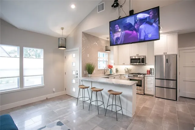 a kitchen with granite countertop a sink stove and cabinets