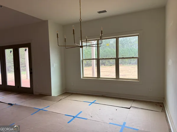 a view of an empty room with a window and fireplace