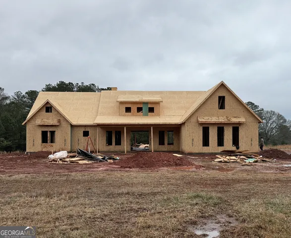 a front view of a house with a yard and trees