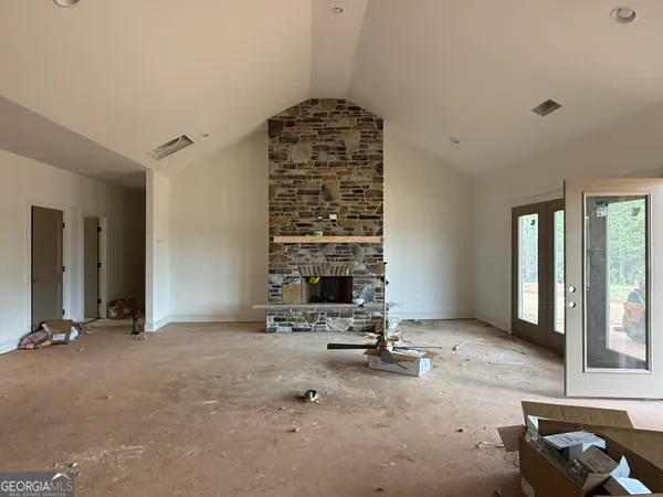 a view of an empty room with a fireplace and a window