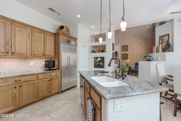 a kitchen with stainless steel appliances granite countertop a stove a sink and a white cabinets