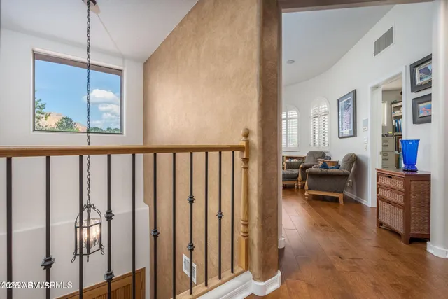 a living room with furniture large window and view of kitchen