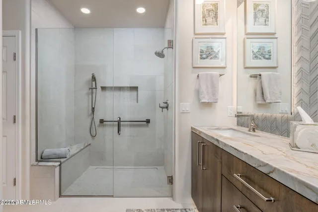 a bathroom with a granite countertop sink a mirror and a shower