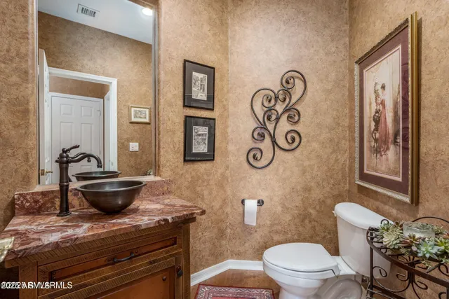 a utility room with stainless steel appliances granite countertop a sink and cabinets