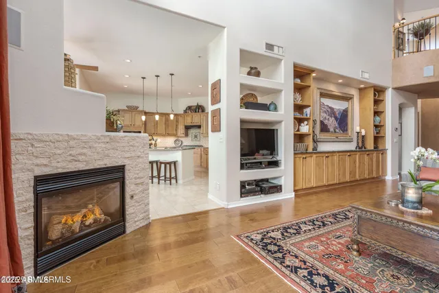 a kitchen with stainless steel appliances granite countertop a stove a sink a refrigerator and a dining table with wooden floor