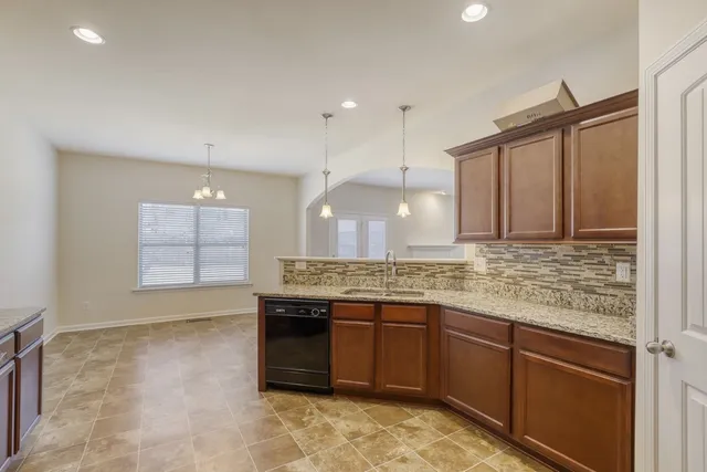 a kitchen with kitchen island granite countertop a stove a sink and a refrigerator