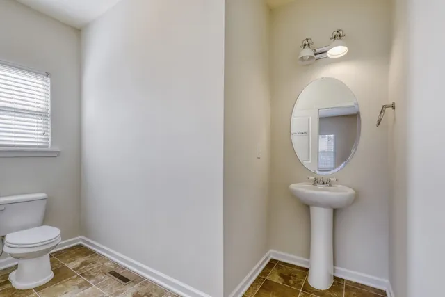 a bathroom with a toilet and a mirror