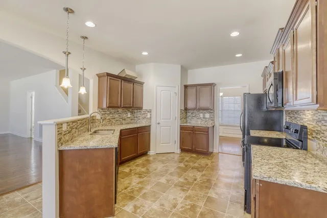 a large kitchen with kitchen island granite countertop a large counter top stainless steel appliances and cabinets