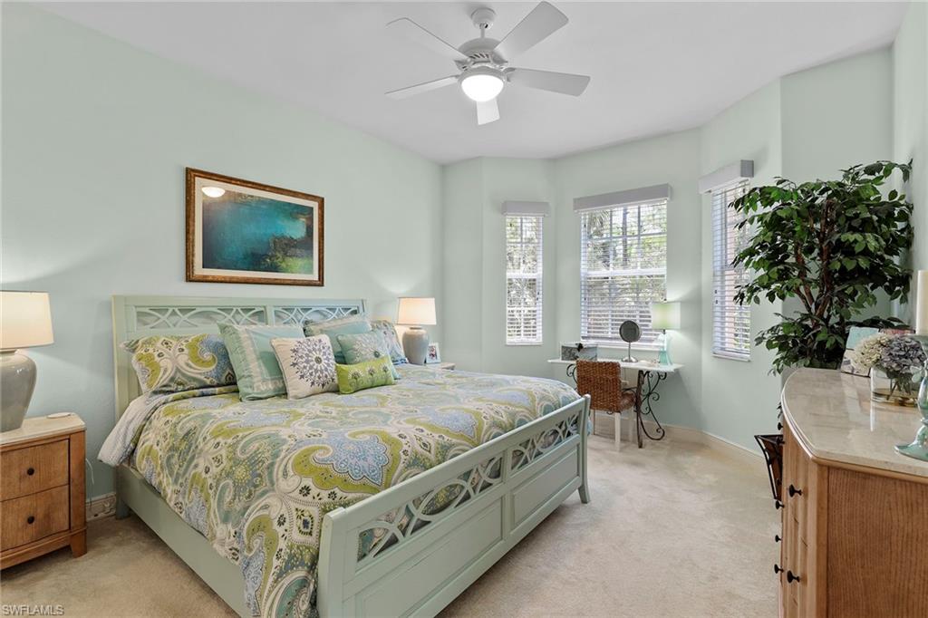 7865 Hawthorne Drive, Unit 402 Naples, FL 34113 - Photo 17 of 33 a bedroom with a bed and a chandelier