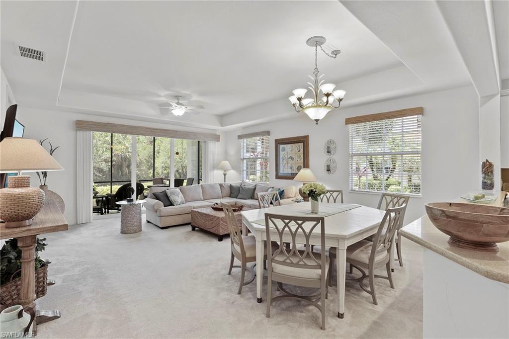 7865 Hawthorne Drive, Unit 402 Naples, FL 34113 - Photo 6 of 33 a living room with furniture a chandelier and a large window