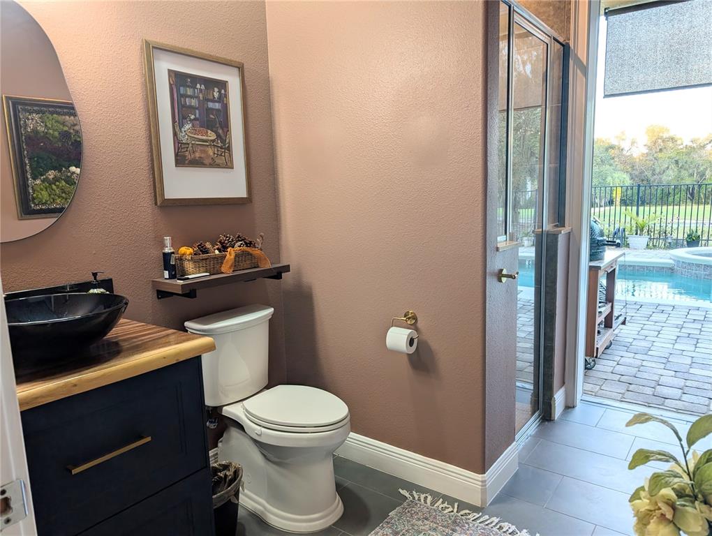 7429 Gathering Court Reunion, FL 34747 - Photo 13 of 40 a bathroom with a toilet a sink and glass door