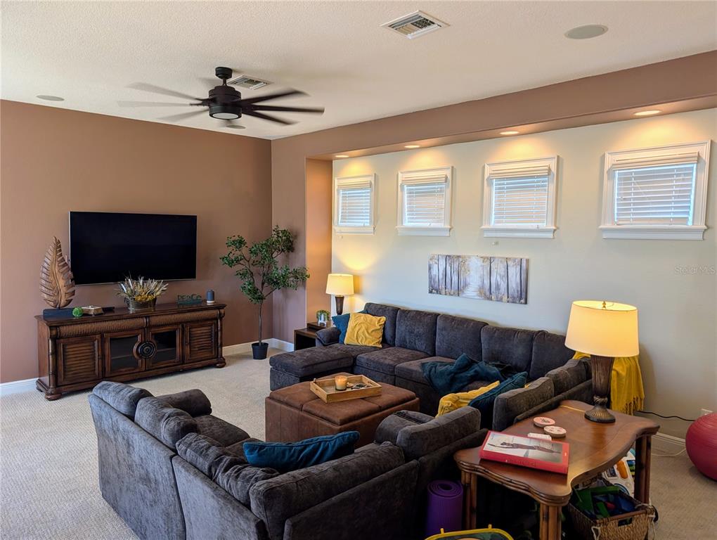 7429 Gathering Court Reunion, FL 34747 - Photo 25 of 40 a living room with furniture and a flat screen tv