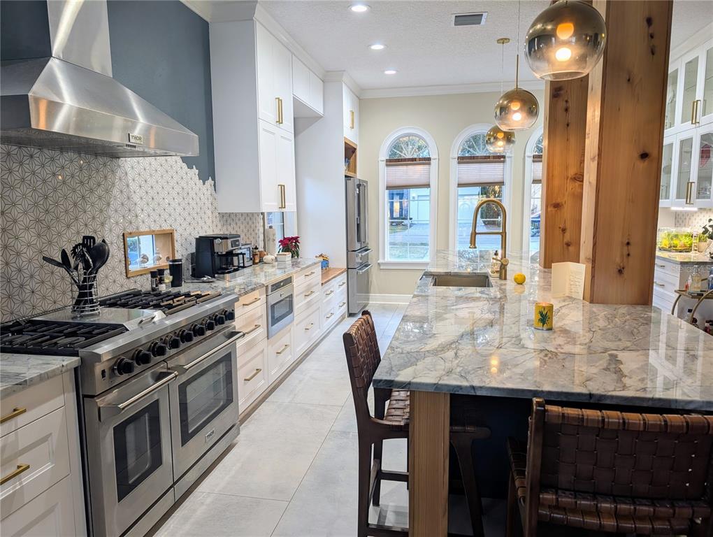 7429 Gathering Court Reunion, FL 34747 - Photo 5 of 40 a kitchen with stainless steel appliances granite countertop a stove and a sink