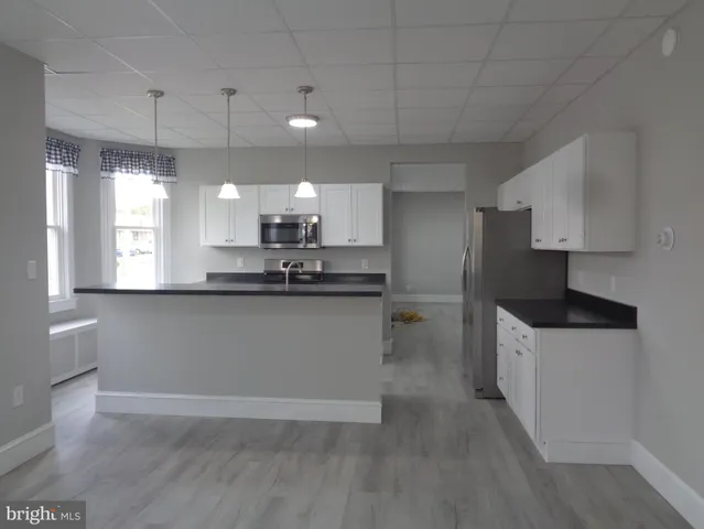 a kitchen with a sink microwave and cabinets