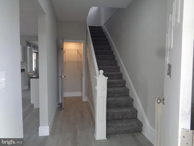 a view of staircase with railing and a window