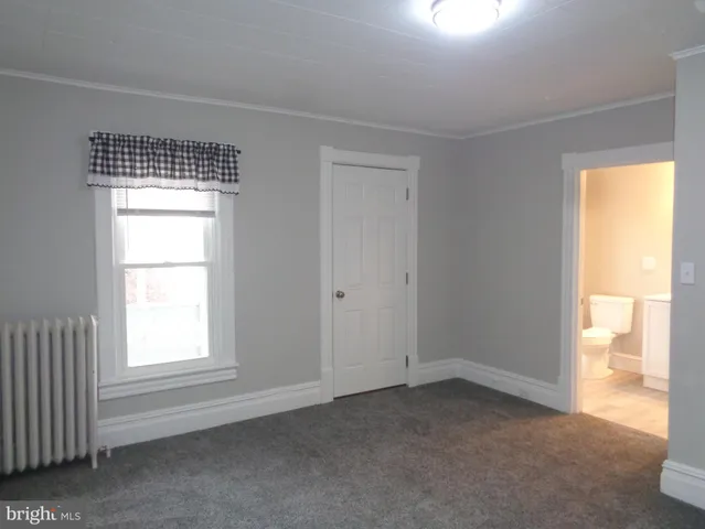 an empty room with closet and a bathroom