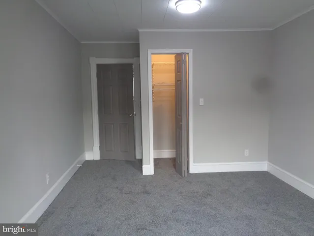 an empty room with windows and closet