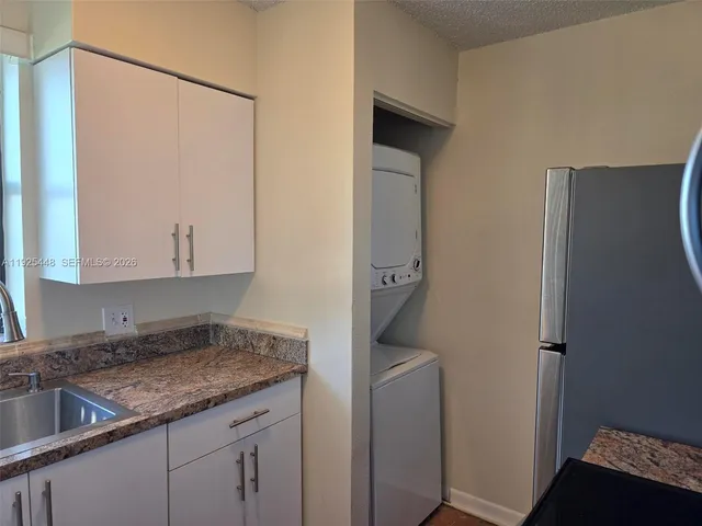 a view of a livingroom with a chandelier fan and windows