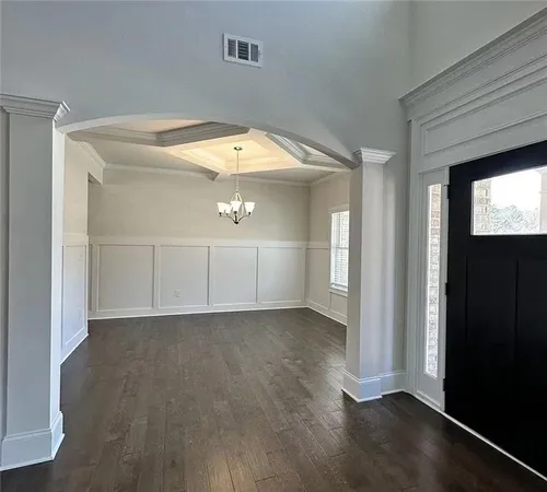 an empty room with wooden floor closet and windows