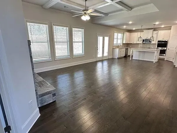 a view of a living room a kitchen and windows