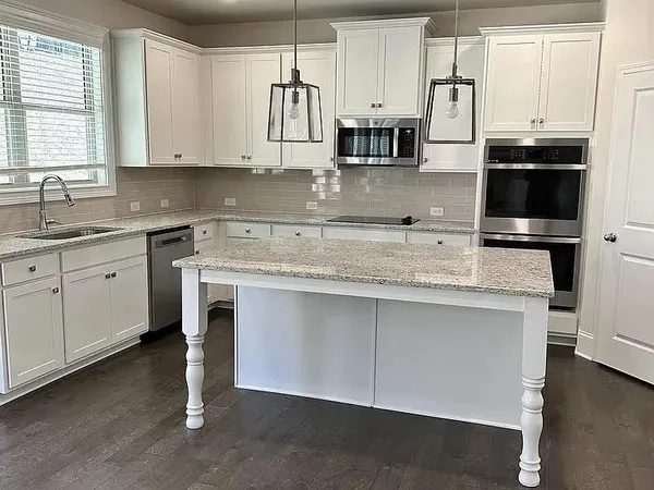 a kitchen with stainless steel appliances granite countertop a sink a stove and a refrigerator