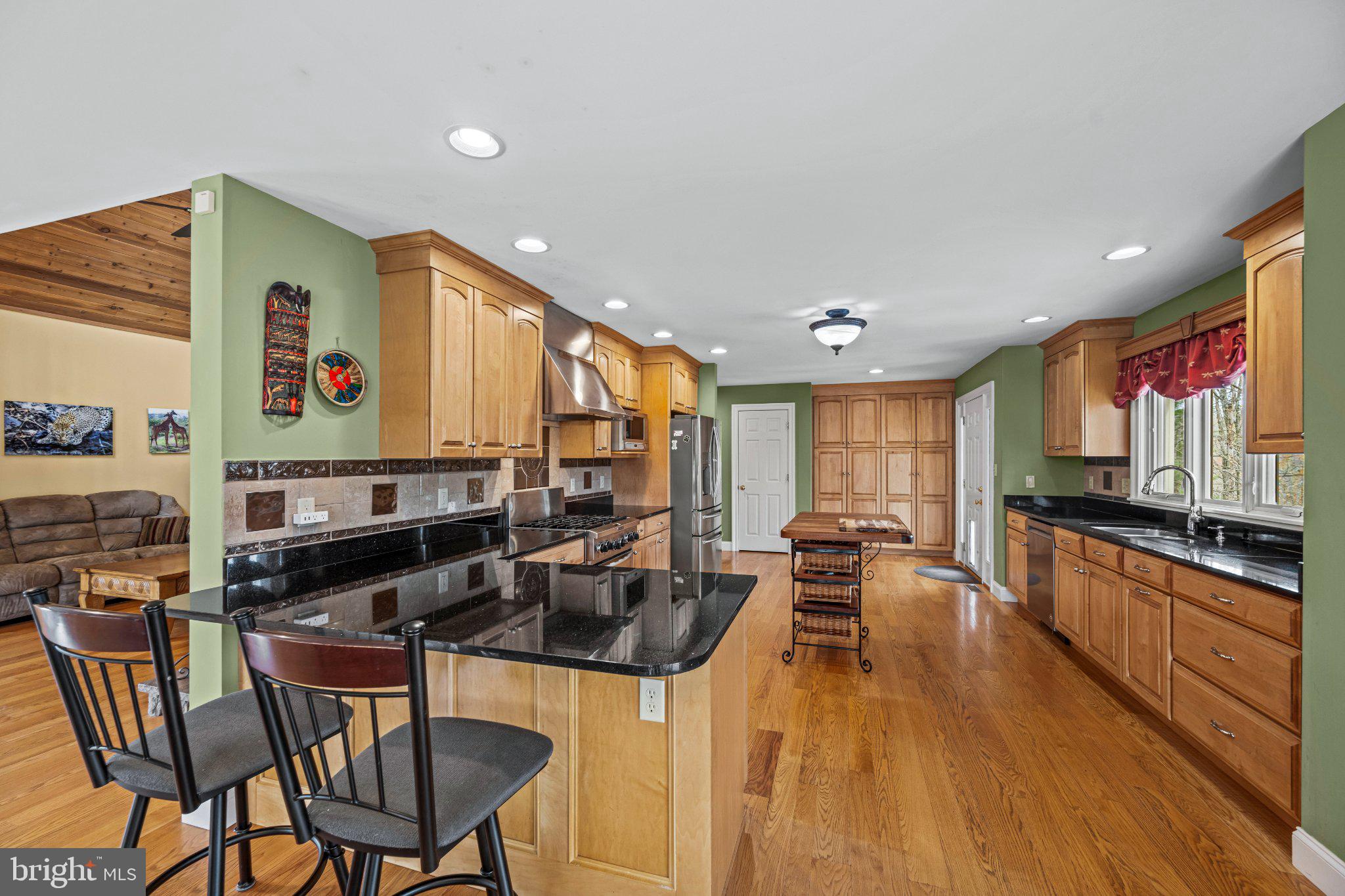 21042 Millers Mill Road Freeland, MD 21053 - Photo 83 of 122 a kitchen with stainless steel appliances granite countertop a stove top oven a sink a dining table and chairs with wooden floor
