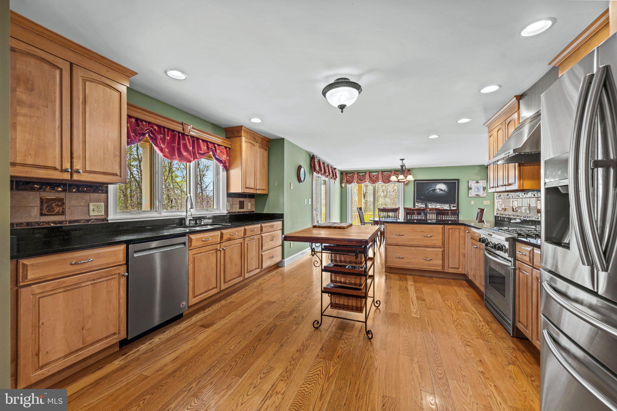 21042 Millers Mill Road Freeland, MD 21053 - Photo 89 of 122 a kitchen with stainless steel appliances kitchen island granite countertop a refrigerator a stove a sink and white cabinets with wooden floor
