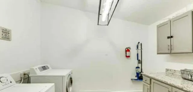 a bathroom with a granite countertop sink a vanity and shower curtain