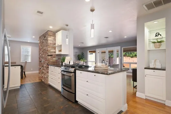 a kitchen with stainless steel appliances kitchen island granite countertop a stove and a sink