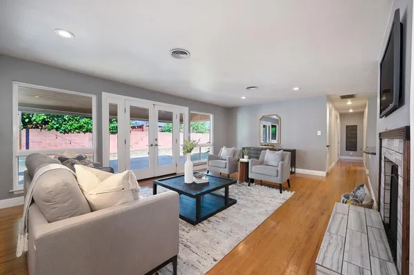 a living room with furniture fireplace and a large window