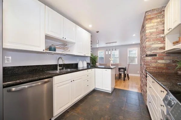 a kitchen with granite countertop white cabinets and white appliances