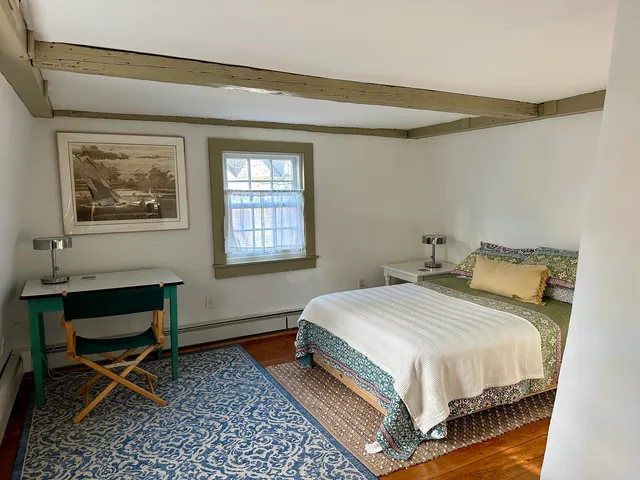 a bedroom with a bed table and chair