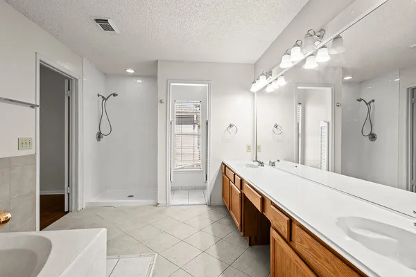 a spacious bathroom with a granite countertop sink mirror and shower