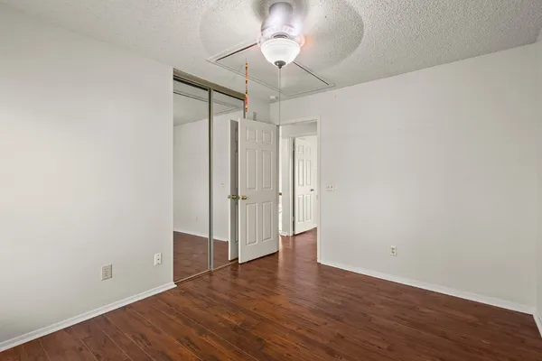 a big room with wooden floor and chandelier fan