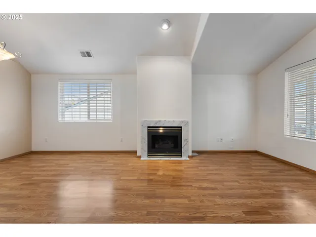 a view of an empty room with window and fireplace