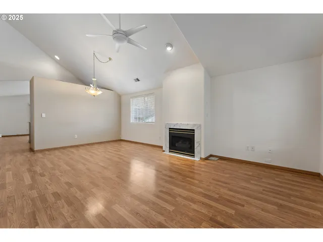 a view of empty room with wooden floor and fireplace