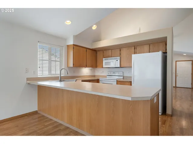 a kitchen with stainless steel appliances granite countertop a sink a refrigerator and a granite counter tops