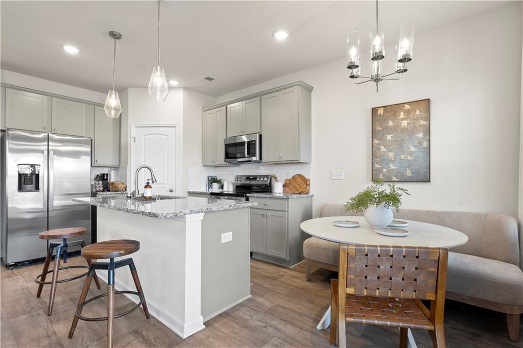 11531 Kimberly Court Hampton, GA 30228 - Photo 13 of 29 a kitchen with kitchen island a dining table chairs stainless steel appliances and cabinets