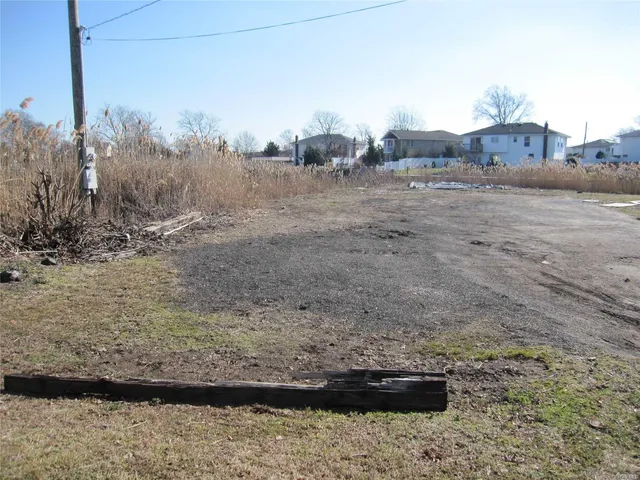 a view of a dry yard with wooden fence