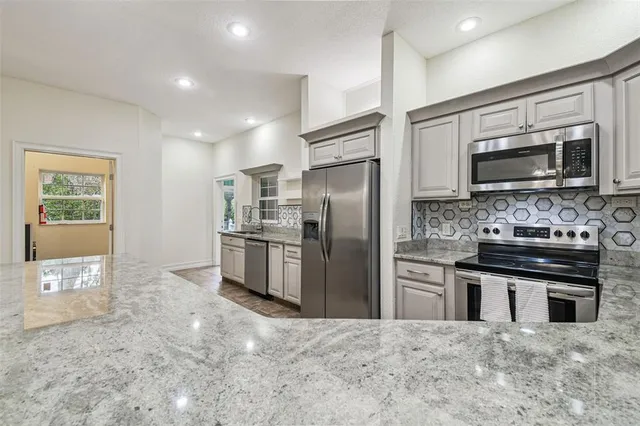 a large kitchen with kitchen island a sink stainless steel appliances and cabinets