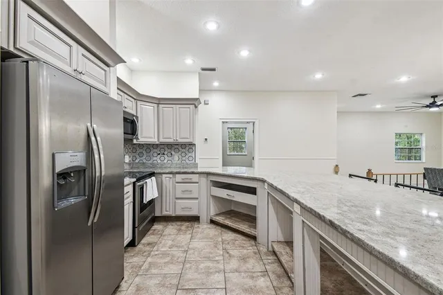 a kitchen with stainless steel appliances granite countertop a stove a sink and a refrigerator