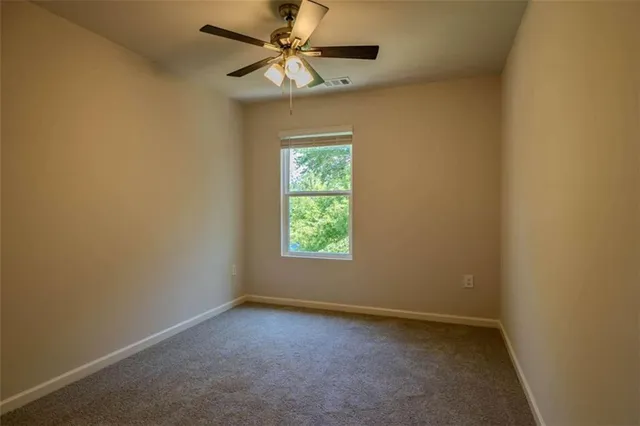 an empty room with a window and a fan