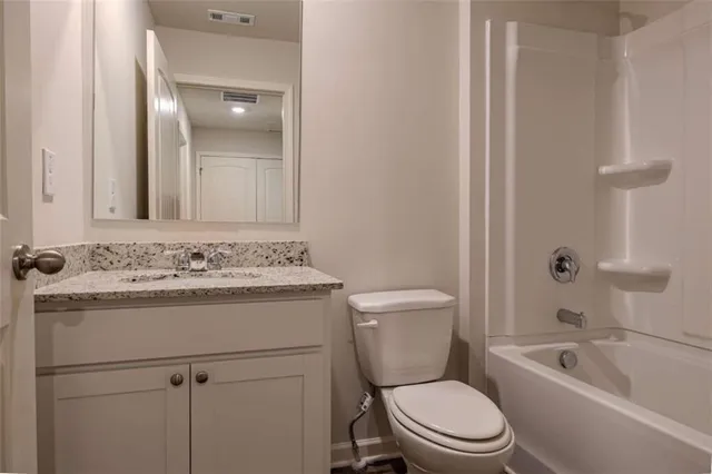 a bathroom with a sink toilet vanity and shower