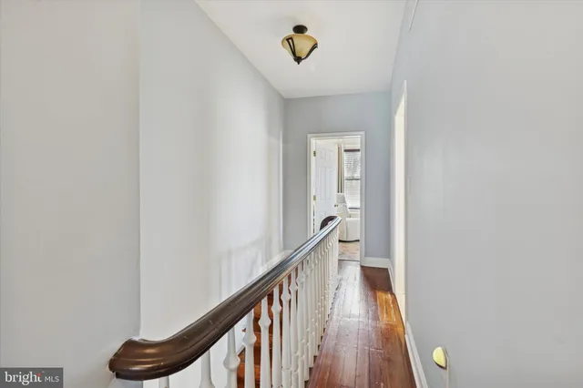 a view of a hallway with wooden floor and stairs